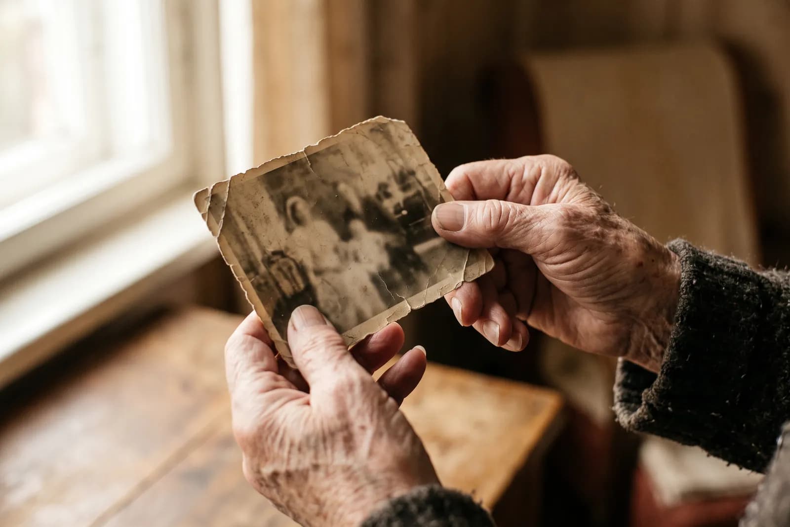 Manos mayores sosteniendo una fotografía familiar antigua